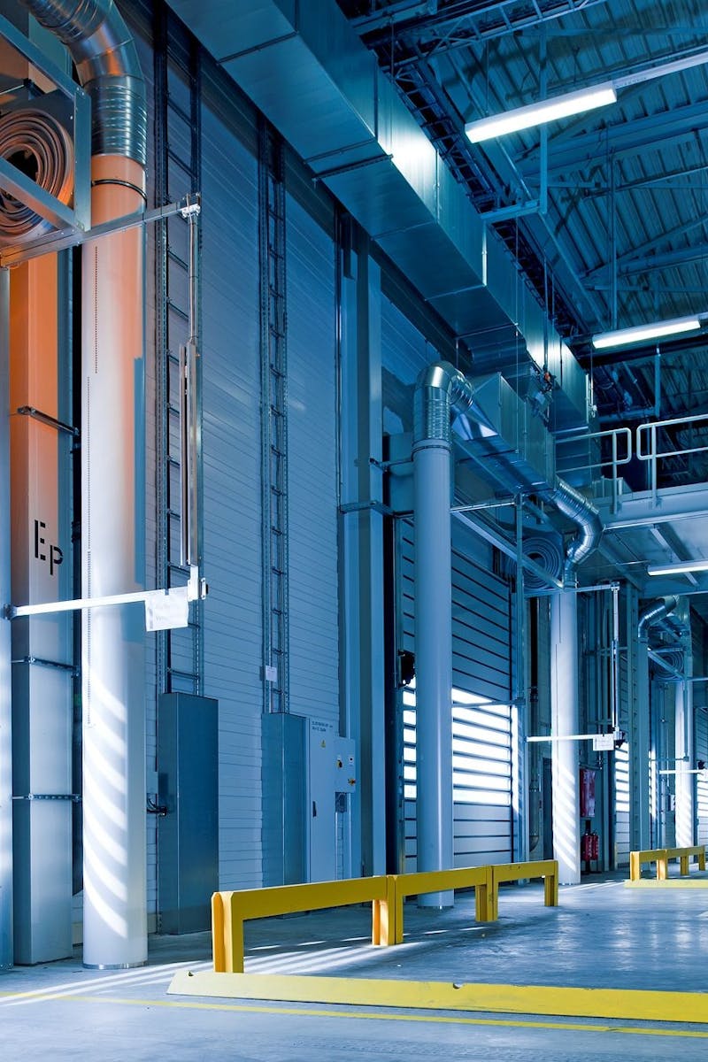 Home Spacious and modern warehouse interior with parked truck and steel structures.